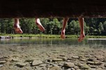 Füße baumeln über klarem Wasser im Nationalpark Hohe Tauern.